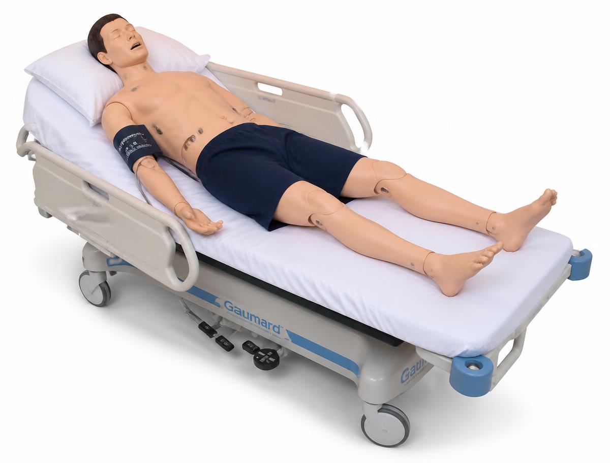 Full-body patient simulator on a hospital bed in a simulation laboratory